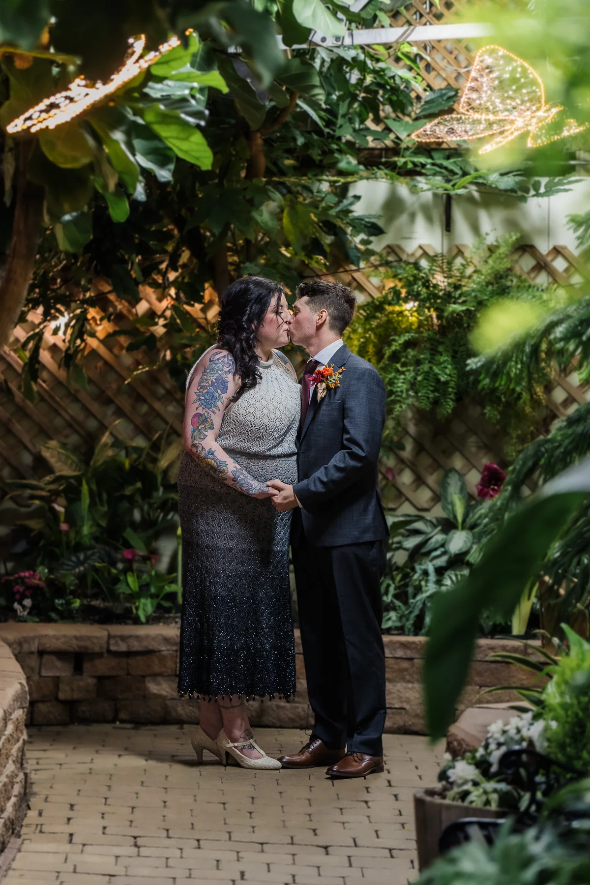 Wedding couple sharing a kiss in a garden setting, warm intimate light